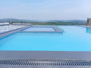a large swimming pool with blue water at The Arcadia Crest-Umroi in Shillong