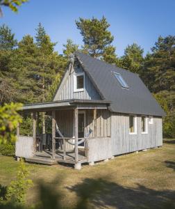 a large wooden house with a gambrel roof at Männiliiva puhkemaja in Hiiumaa