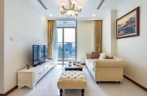 Landmark Vinhomes Christine Apartment في مدينة هوشي منه: غرفة معيشة مع أريكة وتلفزيون