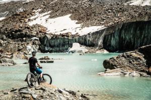 a man riding a bike on a rock near a river at Wellnesshotel Schweizerhof in Saas-Fee