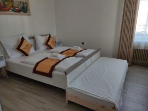 a bedroom with a large white bed with pillows at Pension VIDHOUS 1 in Františkovy Lázně