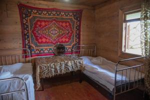 1 dormitorio con 2 camas y tapiz en la pared en Oda, en Khulo