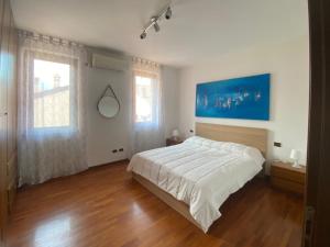 una camera da letto con un grande letto bianco e pavimenti in legno di Stresa Centro a Stresa