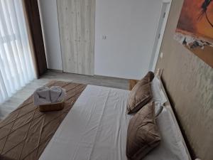 a bedroom with a bed with two pillows on it at Crystal Sands Residence in Eforie Nord