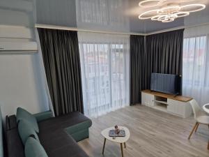 ein Wohnzimmer mit Sofa und Fernseher in der Unterkunft Crystal Sands Residence in Eforie Nord