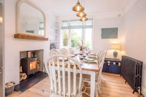a dining room with a table and chairs and a fireplace at Sea House in Southwold