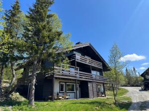 a large black house with a tree in front of it at SKI INN/OUT - 4-room apartment w/3 bedroom in Gaustablikk