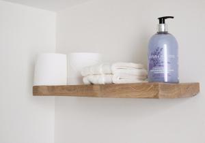 a wooden shelf with towels and a bottle of soap at Pheasant Cottage in Dunkeld