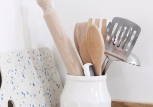 a white vase filled with wooden utensils at Pheasant Cottage in Dunkeld