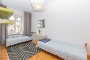 3 camas en una habitación con alfombra en ART Rynek Wrocław en Breslavia