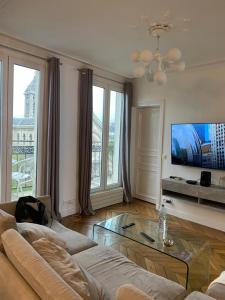 sala de estar con sofá y TV en Bel appartement Montparnasse 70m2 en París