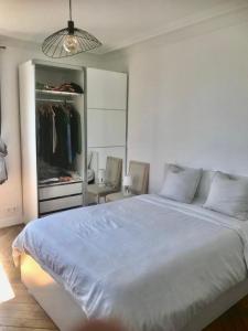 1 dormitorio con 1 cama blanca grande y armario en Bel appartement Montparnasse 70m2 en París