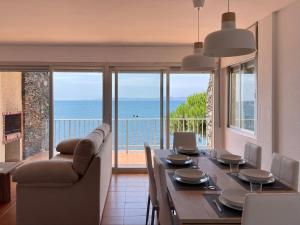 uma sala de jantar com uma mesa e vista para o oceano em Luminoso apartamento frente al mar con piscina em Roses