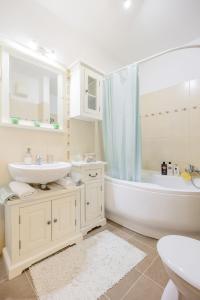 a white bathroom with a tub and a sink and a bath tub at My Old Family Home (with parking near centre) in Budapest