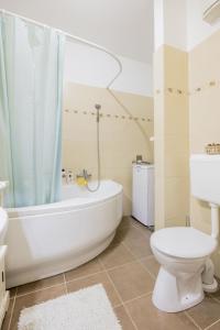 a bathroom with a tub and a toilet and a sink at My Old Family Home (with parking near centre) in Budapest