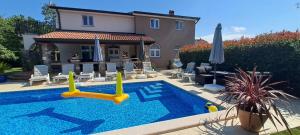 a villa with a swimming pool and a house at Villa AGAVA in Umag
