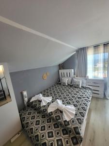 Un dormitorio con una cama con arcos blancos. en Penthouse Apartments PERLA, Vasiliko, en Tsarevo