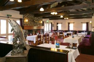 a restaurant with white tables and a shark statue in the middle at Turangi Bridge Motel in Turangi