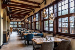 - une salle à manger avec des tables, des chaises et des fenêtres dans l'établissement Wellness Hotel Windsor, à Špindlerův Mlýn