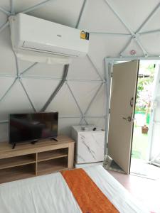 a room with a bed and a tv and a ceiling at Everest Resort Samui - SHA Plus in Mae Nam