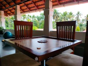 a dining room table with two chairs and a table at Wayanad Mace Mansion in Kenichira