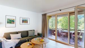 埃塔爾的住宿－Fischer`s Postresidenzen Ettal，客厅配有沙发和桌子