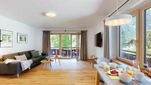 een woonkamer met een bank en een tafel bij Fischer`s Postresidenzen Ettal in Ettal