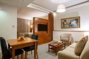 a living room with a couch and a table at Sadeen Amman Hotel in Amman