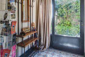 een kamer met een raam en een tafel naast een deur bij Villa Le Port d'attache in Vallauris