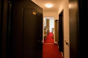 a hallway with a door and a red carpet at Complex Balnear Cozia in Călimăneşti