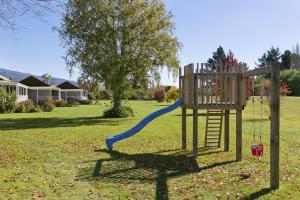 a playground with a slide in a yard at Turangi Bridge Motel in Turangi