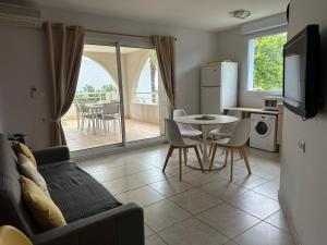 a living room with a table and a kitchen with a patio at Village Naturiste NATUREVA & SPA - Babylone NATURISME in Cap d'Agde