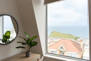 a mirror and a plant in a room with a window at Spacious 4 Bed Victorian House with Sea Views in Ilfracombe