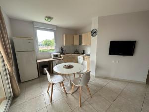 a small kitchen with a table and chairs in a kitchen at Village Naturiste NATUREVA & SPA - Babylone NATURISME in Cap d'Agde +1 photo