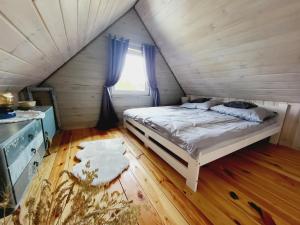 a bedroom with a bed and a window at Przytulny domek w Brajnikach 86 37 in Jedwabno
