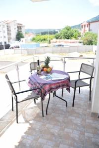 a table and chairs on a balcony with a bottle of wine at Vila Kalina Sutomore in Sutomore