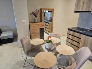 uma sala de jantar com três cadeiras e uma mesa com flores em AGORA luxury APARTMENT 3 em Loutraki