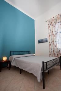 sypialnia z 2 łóżkami i niebieską ścianą w obiekcie Casa Dafne w mieście Livorno