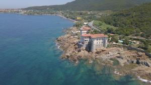 una vista aerea di un edificio su un'isola rocciosa in acqua di Casa Dafne a Livorno