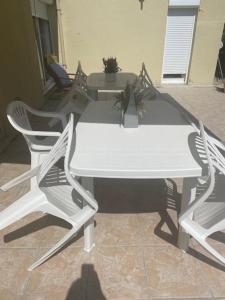 un tavolo con due sedie e un tavolo e sedie bianchi di Agréable chambre a Menucourt
