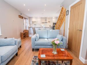 a living room with two blue couches and a table at Olive Cottage in York