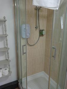 y baño con ducha y puerta de cristal. en Lovely Wee House in Lundin Links perfect beaches, en Lundin Links