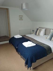 a bedroom with a large bed with towels on it at Lovely Wee House in Lundin Links perfect beaches in Lundin Links