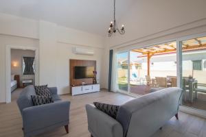 een woonkamer met 2 banken en een televisie bij SunTeos Villa Suites in Fethiye