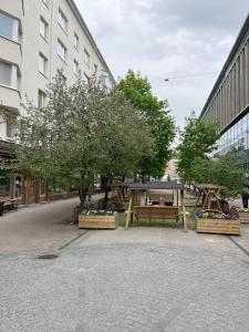 a park with two picnic tables and a tree at Tampereen kunkku in Tampere