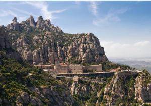 una montagna con un monastero in cima di Raco de Lis a La Torre de Claramunt