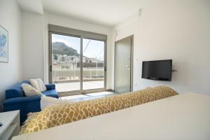 a bedroom with a bed and a couch and a tv at Athens city center maisonette for 3 persons by MPS in Athens