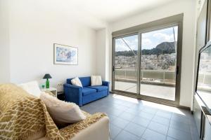 a living room with a blue chair and a window at Athens city center maisonette for 3 persons by MPS in Athens