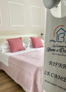 uma cama branca com uma placa num quarto em Le Camere di Libero e Roberta em Tropea