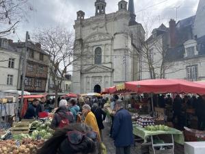 un grupo de personas en un mercado al aire libre frente a una iglesia en La Pause, en Saint-Martin-de-la-Place